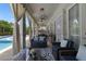 Inviting outdoor living space with comfortable seating, elegant curtains, and pool view at 17551 Black Rail St, Windermere, FL 34786