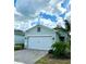 Charming single-Gathering home featuring lush landscaping, a paver driveway, and a two-car garage at 2042 Key Bay Trl, Kissimmee, FL 34747