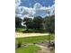 Scenic view of the golf course, lush green grass, tall trees, and cloudy blue skies at 2042 Key Bay Trl, Kissimmee, FL 34747