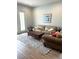 Cozy living room featuring wood-look tile floors and comfortable seating arrangement at 2042 Key Bay Trl, Kissimmee, FL 34747
