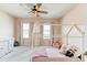 Charming bedroom with soft pink walls, decorative bed frame, and plenty of natural light from the large windows at 2149 Tudor Rose Dr, Sanford, FL 32773