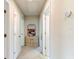 Bright hallway featuring neutral walls, white trim, decorative artwork, and multiple doorways at 2149 Tudor Rose Dr, Sanford, FL 32773