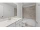 Bathroom featuring a vanity, a large mirror, and a shower-tub combo with tiled walls at 2563 Relaxing Ln, Kissimmee, FL 34744