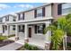 Inviting two-story townhome with a covered porch, complemented by lush landscaping and palm trees at 2563 Relaxing Ln, Kissimmee, FL 34744