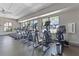 Community fitness center with modern equipment and large windows overlooking the pool at 2563 Relaxing Ln, Kissimmee, FL 34744