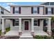 Charming two-story townhome featuring a covered porch and neutral-toned facade with contrasting shutters at 2563 Relaxing Ln, Kissimmee, FL 34744