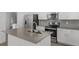 Modern kitchen features stainless steel appliances, grey backsplash, and center island with sink at 2563 Relaxing Ln, Kissimmee, FL 34744