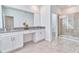 Modern bathroom featuring double sinks, vanity, and a glass-enclosed shower for a spa-like experience at 2665 Petition Ln, Kissimmee, FL 34746