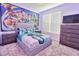 A bedroom with a large Toy Story mural, neutral colors, and carpet at 2665 Petition Ln, Kissimmee, FL 34746