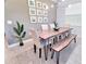 Dining area with unique wood table, bench seating and stylish wall decor at 2665 Petition Ln, Kissimmee, FL 34746