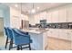 Stylish kitchen features a gray tile backsplash, stainless appliances, and a central island with bar stool seating at 2665 Petition Ln, Kissimmee, FL 34746