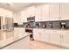 Bright kitchen boasts stainless appliances, white cabinetry, and gray tile backsplash at 2665 Petition Ln, Kissimmee, FL 34746