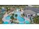 Aerial view of a large community pool with palm trees, lounge chairs, and covered seating areas at 2665 Petition Ln, Kissimmee, FL 34746
