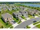 A high-angle view captures the house, driveway, and yard amid a community with a pond in the distance at 2817 Muller Oak Loop, Ocoee, FL 34761