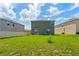 A spacious backyard with lush green grass, enclosed by neighboring houses and sliding glass door access at 2817 Muller Oak Loop, Ocoee, FL 34761