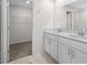 Bathroom with double vanity sinks, a walk-in closet, and clean contemporary design at 2817 Muller Oak Loop, Ocoee, FL 34761