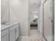 Bright bathroom featuring a modern vanity, mirror, and a glass-enclosed shower, adjacent to the bedroom at 2817 Muller Oak Loop, Ocoee, FL 34761
