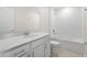 Bathroom featuring a vanity with sleek fixtures and a tub with white tiles around the bath and shower area at 2817 Muller Oak Loop, Ocoee, FL 34761