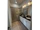 Modern bathroom featuring double sinks, granite countertops, and a glass-enclosed shower at 306 Captiva Dr, Davenport, FL 33896