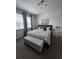 Inviting bedroom with natural light, carpeted floors, a bed and tufted bench at 306 Captiva Dr, Davenport, FL 33896