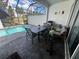 Covered outdoor dining area with a view of the inviting in-ground pool and lush landscaping at 306 Captiva Dr, Davenport, FL 33896
