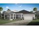 Charming single-story home featuring a covered front porch, two-car garage, and neat landscaping at 308 Free Range Dr, Clermont, FL 34715