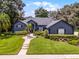 Beautifully landscaped front yard with lush lawn, mature trees, and elegant walkway to the home's entrance at 315 Lake Rd, Lake Mary, FL 32746