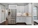 Bright kitchen with white cabinets, stainless steel refrigerator and stylish backsplash at 315 Lake Rd, Lake Mary, FL 32746