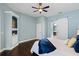 This main bedroom features a ceiling fan, dark wood floors, and a white sliding door leading to the bathroom at 315 Lake Rd, Lake Mary, FL 32746