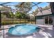 Inviting pool surrounded by a screened enclosure and lush landscaping with the home in the background at 315 Lake Rd, Lake Mary, FL 32746