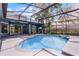 Inviting pool surrounded by a screened enclosure and lush landscaping with the home in the background at 315 Lake Rd, Lake Mary, FL 32746