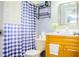 Bathroom featuring a wooden vanity, large mirror and a blue and white checkered shower curtain at 339 Colony Ct, Kissimmee, FL 34758