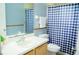 Bathroom featuring a white sink and toilet with a blue and white checkered shower curtain at 339 Colony Ct, Kissimmee, FL 34758