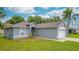 Charming single-story home featuring a well-maintained lawn, blue siding, and two-car garage at 339 Colony Ct, Kissimmee, FL 34758