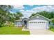 Charming single-story home featuring a well-maintained lawn, blue siding, and two-car garage at 339 Colony Ct, Kissimmee, FL 34758