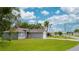 Charming one-story home featuring a well-manicured lawn, mature trees, and a gray exterior at 339 Colony Ct, Kissimmee, FL 34758