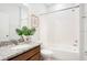 A well-lit bathroom featuring granite counters, decorative planting and a tub with shower at 3408 Curlew Ave, Leesburg, FL 34748