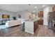 Open kitchen with island, stainless appliances, and seamless flow to the living area at 3408 Curlew Ave, Leesburg, FL 34748
