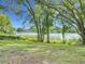 Backyard view with lush trees looking at a lake with other homes at 3417 Pershing Ave, Orlando, FL 32812
