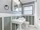 Stylish bathroom featuring a classic pedestal sink, framed mirror, and decorative trim work at 3417 Pershing Ave, Orlando, FL 32812