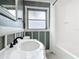 Bright bathroom features a classic vanity, gray accents, and a shower-tub combination at 3417 Pershing Ave, Orlando, FL 32812