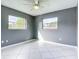 Inviting bedroom with tiled floor, ceiling fan, and large windows letting in natural light at 3417 Pershing Ave, Orlando, FL 32812