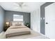 Well-lit bedroom featuring gray walls, a ceiling fan, a comfortable bed, and ample closet space at 3417 Pershing Ave, Orlando, FL 32812