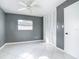 Neutral bedroom with a ceiling fan, a large window, and closet storage at 3417 Pershing Ave, Orlando, FL 32812
