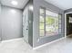 Bright foyer boasts neutral walls, white tiled floors, front door and window with view to front porch at 3417 Pershing Ave, Orlando, FL 32812