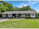 Exterior view of the house with a beautifully landscaped front yard and dark exterior at 3417 Pershing Ave, Orlando, FL 32812