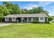 Charming single story home featuring a manicured lawn, mature trees, and a welcoming front porch at 3417 Pershing Ave, Orlando, FL 32812
