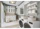 Well-organized laundry room with washer, dryer, storage cabinets, and shelving at 3417 Pershing Ave, Orlando, FL 32812