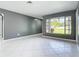 Spacious living room features neutral walls, white tiled floors, and a large window to the front yard at 3417 Pershing Ave, Orlando, FL 32812