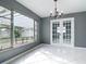 Sunlit living room featuring tile flooring, backyard view, and modern chandelier at 3417 Pershing Ave, Orlando, FL 32812